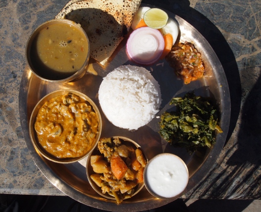 from above: Nepalese Vegetarian food: basmati rice, black lentils, vegetable curry, spinach green curry, pickle, papad (some kind of mushroom curry?), salad and curd. 